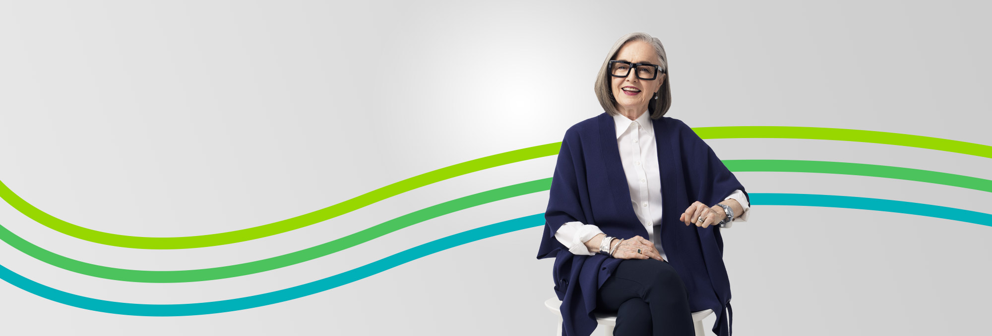 smiling retired woman in glasses featured in an article about revisiting your financial plan